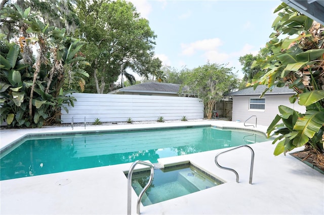 view of swimming pool with an in ground hot tub