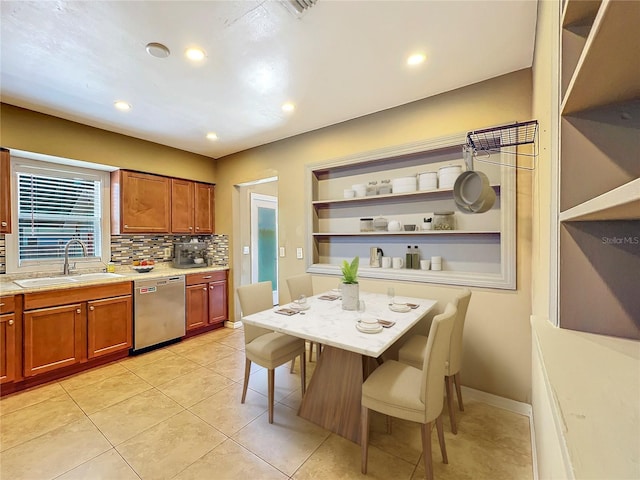 kitchen featuring tasteful backsplash, a breakfast bar, sink, light tile patterned floors, and dishwasher