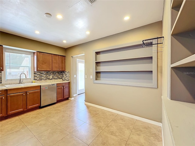 kitchen with decorative backsplash, sink, light tile patterned floors, and stainless steel dishwasher