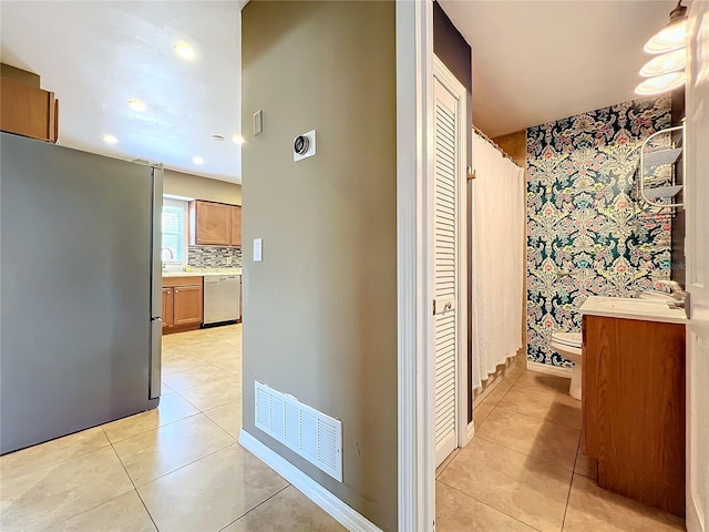 hallway with sink and light tile patterned floors