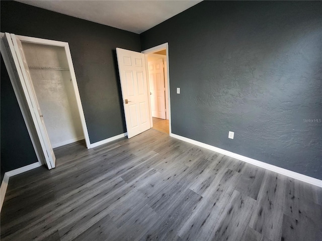 unfurnished bedroom with a closet and wood-type flooring