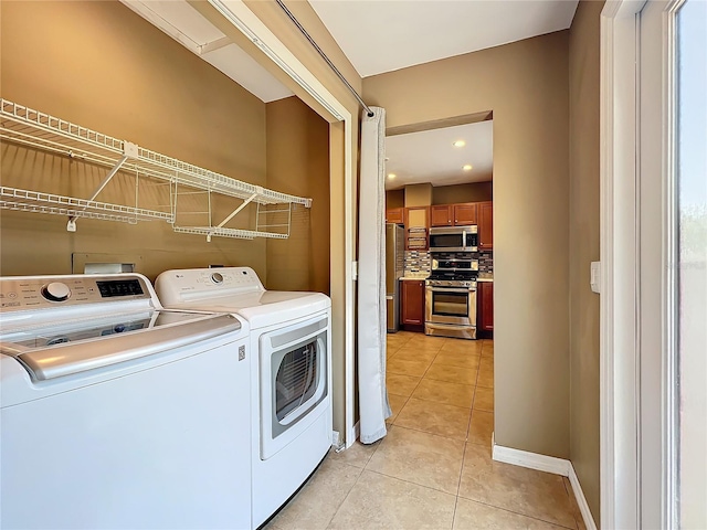 laundry area featuring light tile patterned flooring and washing machine and clothes dryer