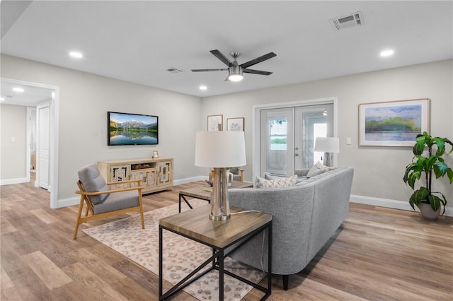 living area with french doors, visible vents, light wood-style flooring, and baseboards