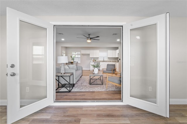 doorway to outside featuring a textured ceiling, visible vents, and wood finished floors