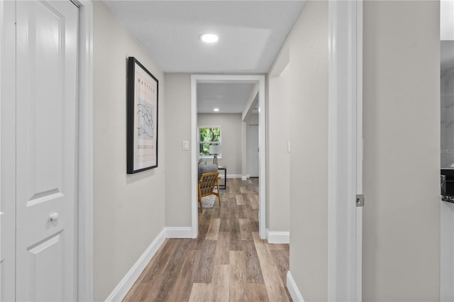 hall with light wood finished floors and baseboards