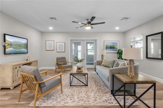 living room featuring light wood-style floors, a healthy amount of sunlight, and visible vents