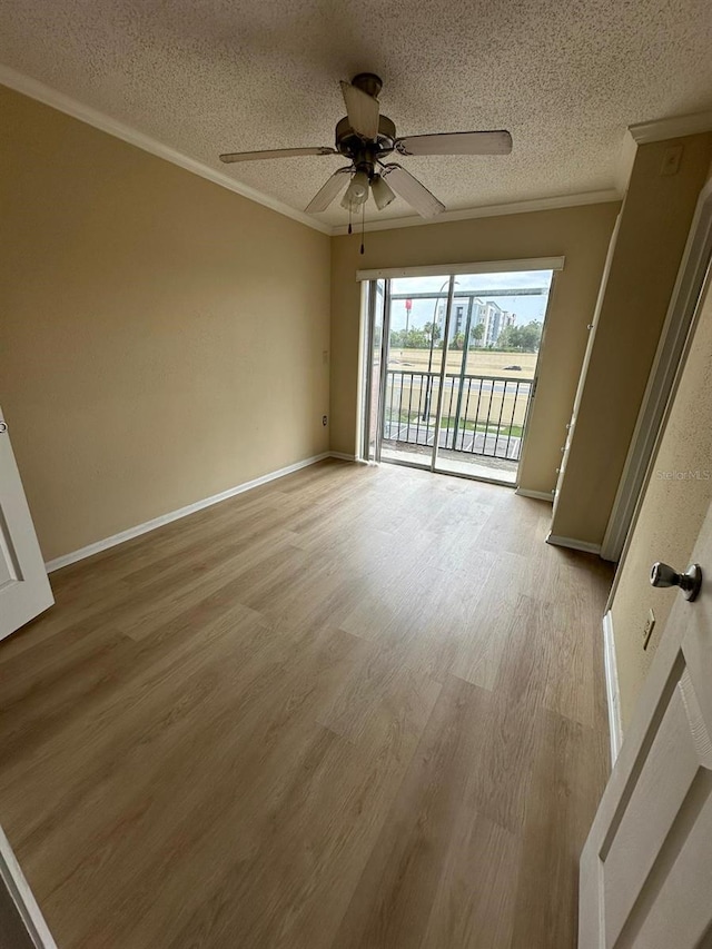 empty room with ceiling fan, light hardwood / wood-style flooring, a textured ceiling, and ornamental molding