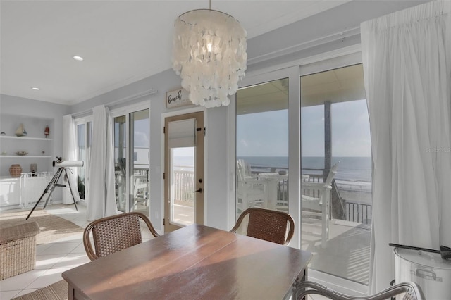 tiled dining area featuring a notable chandelier and a water view