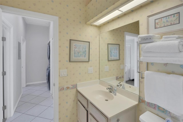 bathroom with tile flooring, oversized vanity, and stacked washer / drying machine