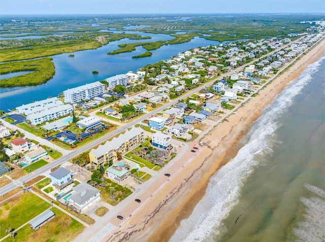 drone / aerial view featuring a water view and a view of the beach