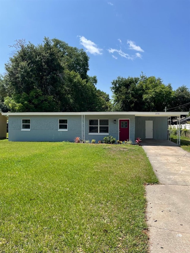 view of front of property with a front yard and a carport