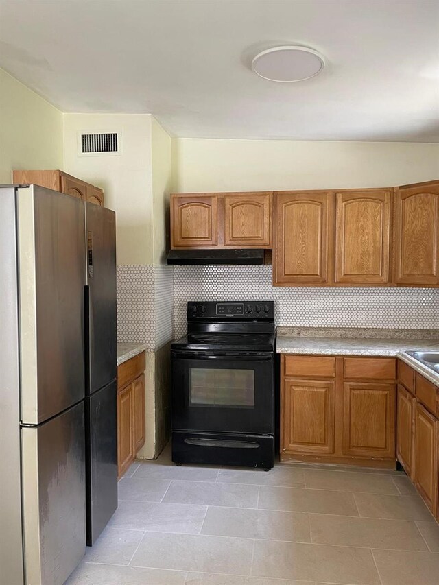 kitchen featuring sink, electric range, stainless steel refrigerator, and light tile floors