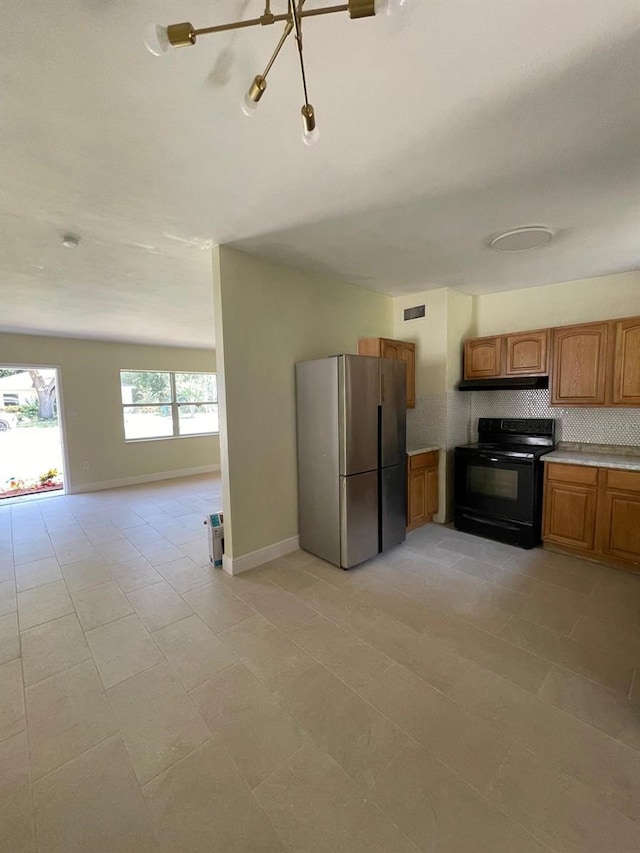 kitchen with light tile flooring, electric range, and stainless steel refrigerator