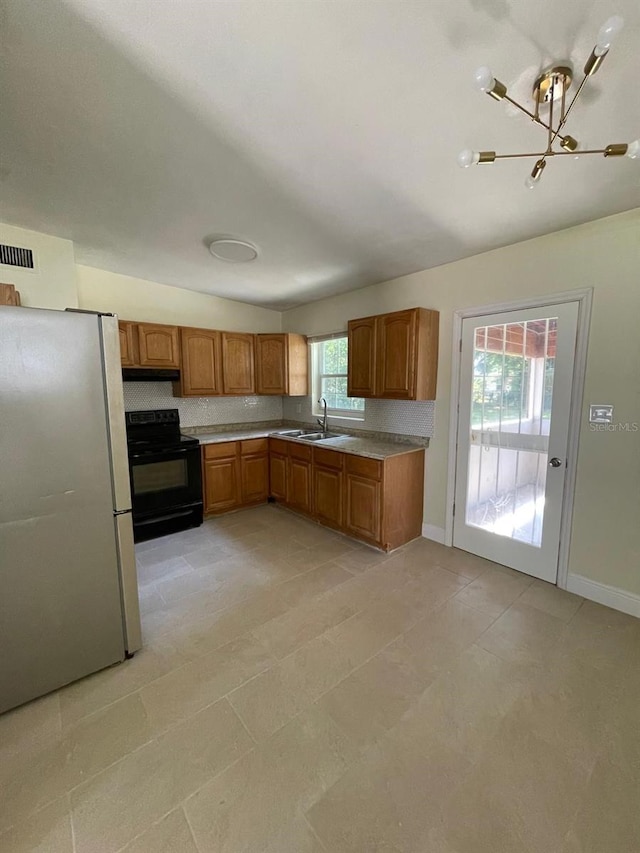 kitchen with black electric range oven, light tile flooring, a wealth of natural light, and white fridge