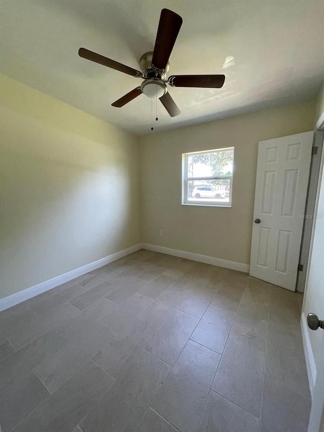 spare room with ceiling fan and tile floors