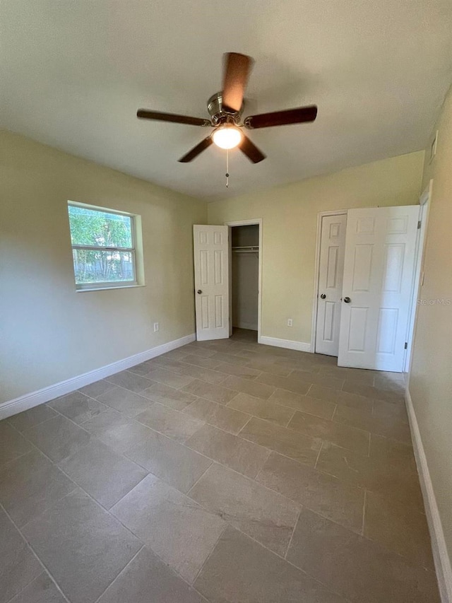 unfurnished bedroom featuring tile flooring, ceiling fan, and a closet