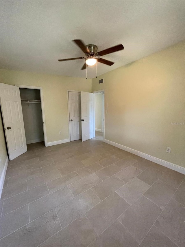 unfurnished bedroom featuring tile flooring, a closet, and ceiling fan