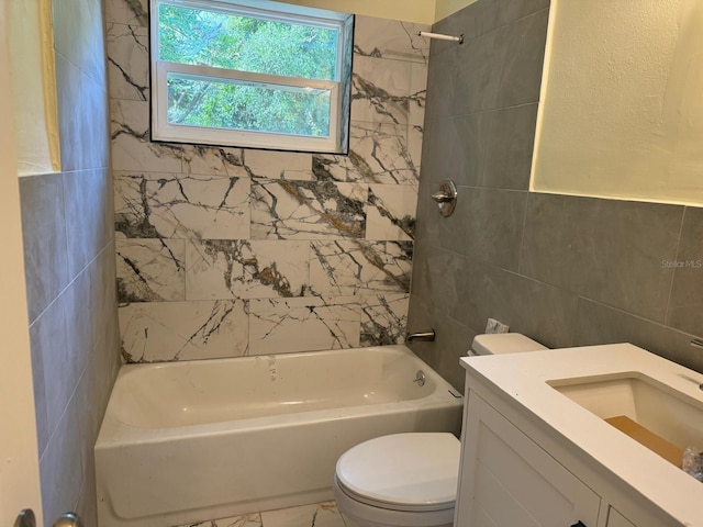 full bathroom with tile flooring, tiled shower / bath, tile walls, vanity, and toilet