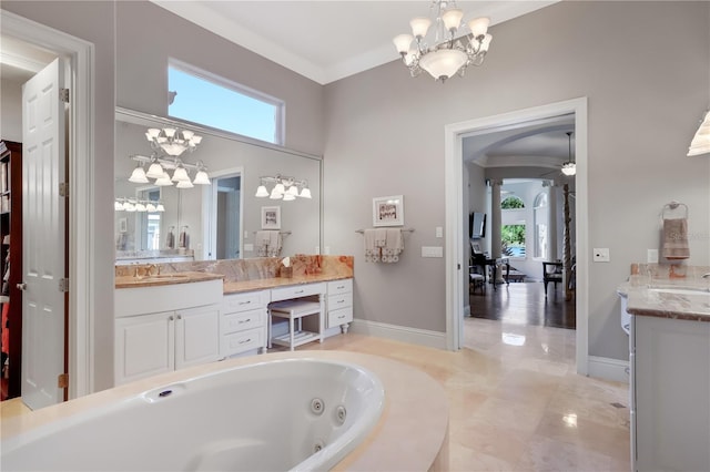 bathroom with ceiling fan with notable chandelier, plenty of natural light, and vanity