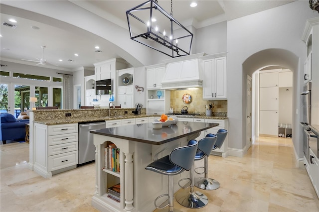 kitchen featuring premium range hood, light tile flooring, a center island, and appliances with stainless steel finishes