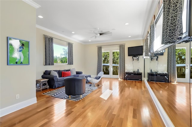 living room featuring plenty of natural light, light hardwood / wood-style flooring, ceiling fan, and ornamental molding