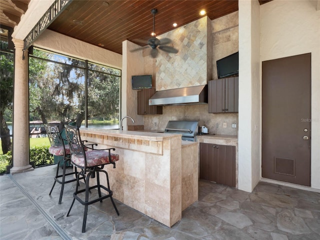 view of patio with area for grilling, ceiling fan, and sink