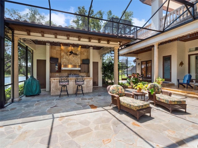 view of patio / terrace with a bar, ceiling fan, and a balcony