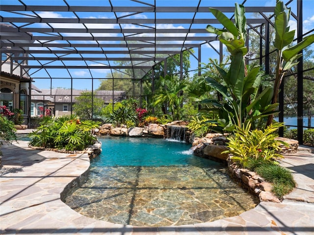 view of swimming pool with a patio area, pool water feature, and a lanai