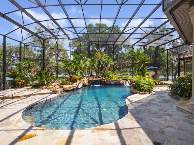 view of pool with a lanai, pool water feature, and a patio area