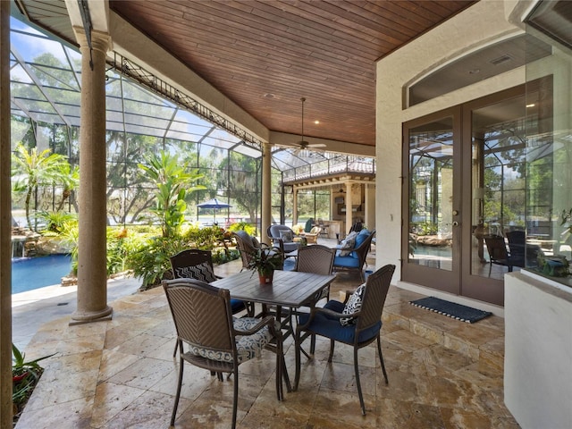 sunroom / solarium featuring wooden ceiling and decorative columns