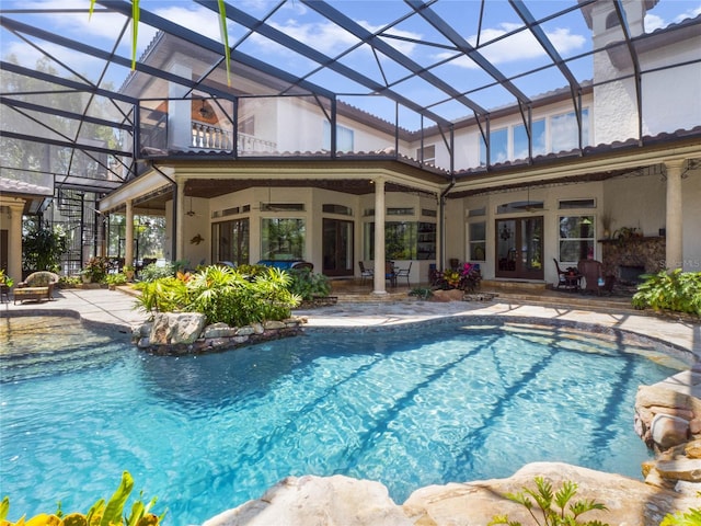 view of swimming pool featuring a patio, french doors, and a lanai