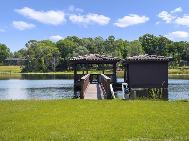 view of dock with a water view and a lawn