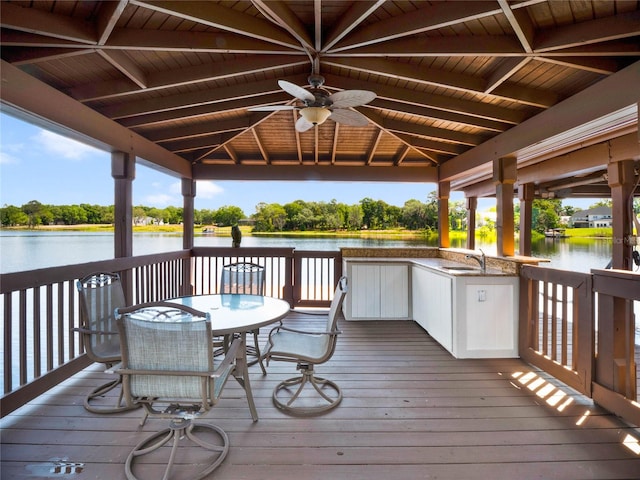 deck featuring ceiling fan, sink, and a water view