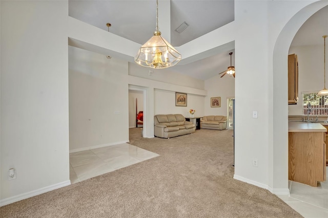 interior space with ceiling fan, high vaulted ceiling, sink, and light colored carpet