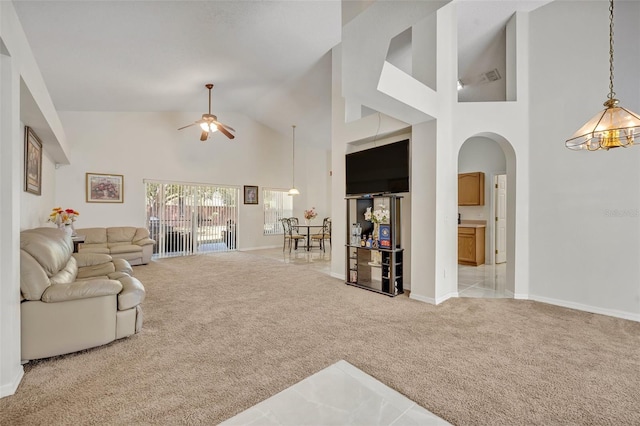 living room with ceiling fan, high vaulted ceiling, and light carpet