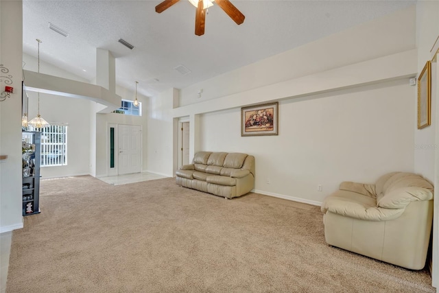 living room with high vaulted ceiling, ceiling fan, carpet flooring, and a textured ceiling