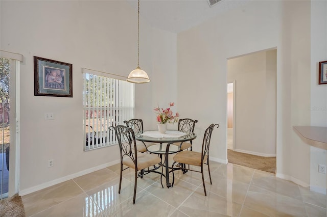 tiled dining room with a high ceiling