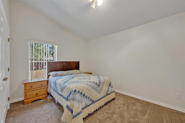 carpeted bedroom featuring vaulted ceiling and a textured ceiling