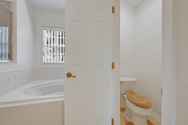 bathroom with a relaxing tiled tub and toilet