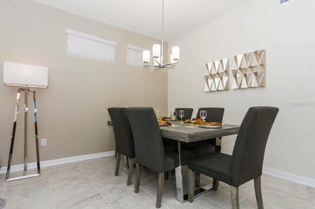 tiled dining room featuring an inviting chandelier