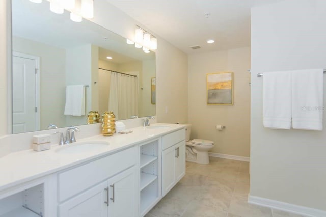 bathroom with tile floors, dual bowl vanity, and toilet