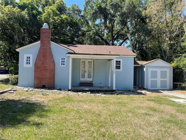 view of front of property featuring a front lawn and a storage unit