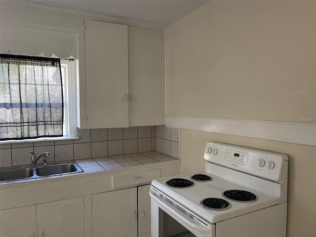 kitchen with white cabinets, white stove, and sink