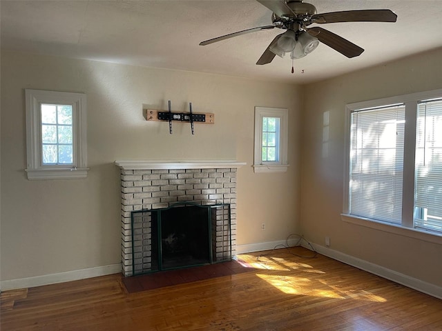 unfurnished living room featuring wood-type flooring, ceiling fan, and a fireplace