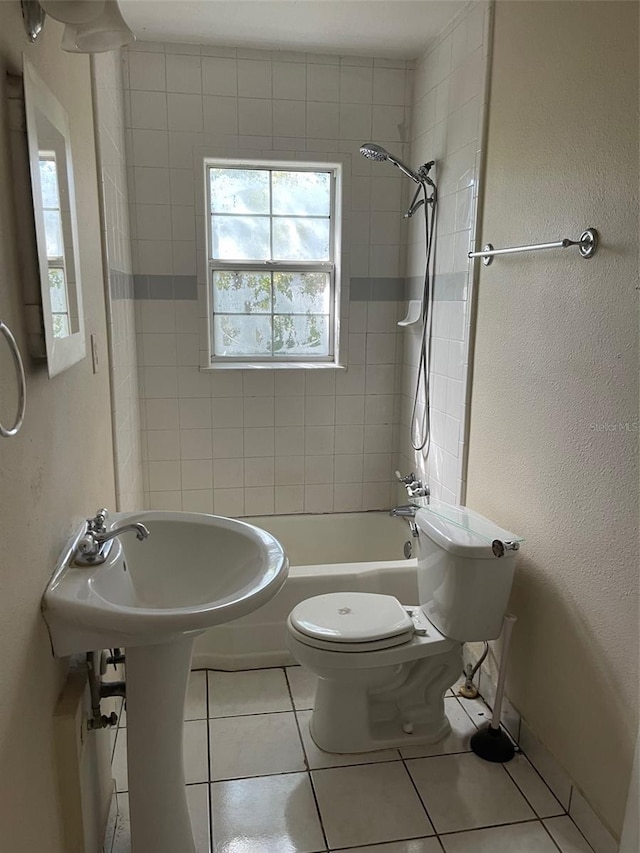 bathroom featuring toilet, tiled shower / bath, and tile flooring