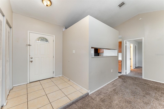 entryway featuring light carpet and vaulted ceiling