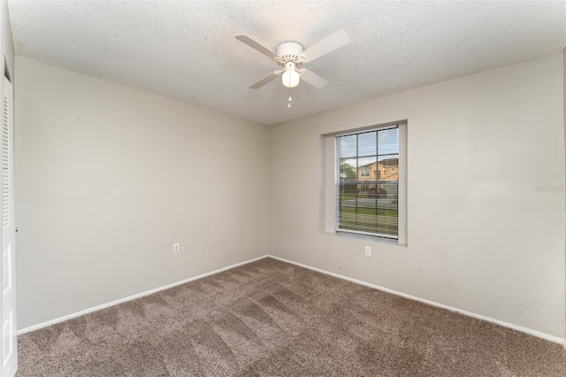 carpeted empty room with a textured ceiling and ceiling fan