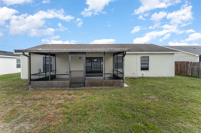 back of house featuring a yard and a sunroom