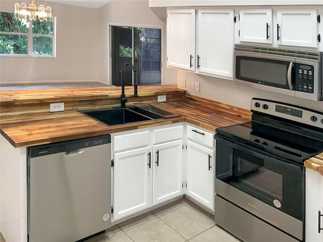 kitchen featuring wooden counters, white cabinets, sink, a chandelier, and stainless steel appliances