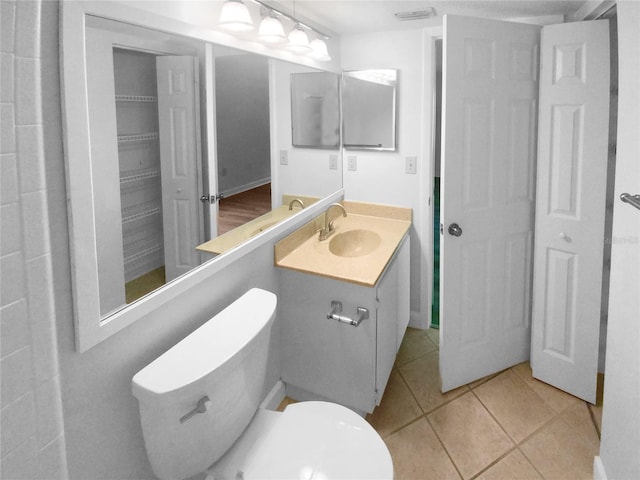 bathroom with tile floors, toilet, and large vanity